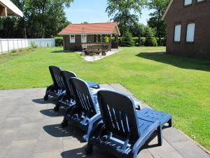 una fila de sillas negras sentadas en un patio en Ferienhaus INGE MOOR203 ruhig gelegen im Hinterland der NORDSEE, en Südbrookmerland