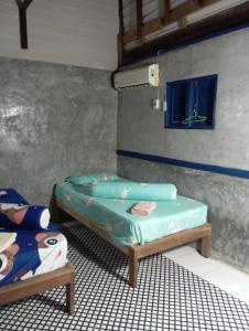 a room with two twin beds and a window at Villa Somkid in Ban Hua Laem