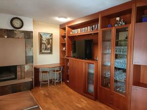 a living room with a bar and a tv in a room at Casa con jardín y piscina privada. in Santa Eulalia de Ronsaná