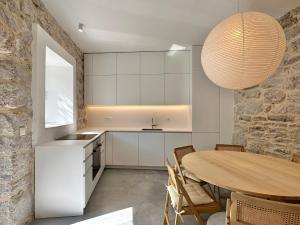 a kitchen with a table and a stone wall at Strp House in Strp
