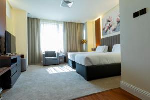a hotel room with two beds and a television at Park Avenues Hotel in Kuwait