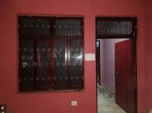 Habitación con 2 puertas rojas y pared roja. en Mishra Bhawan, en Dārāganj