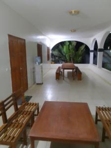 a room with two wooden benches and a room with a table at Somone villa avec piscine et mer in Somone