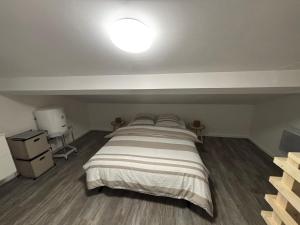 una camera da letto con un grande letto e una luce sul soffitto di Petite maison au calme a Pont-de-Larn