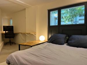 une chambre avec un lit avec un bureau et une fenêtre dans l'établissement Etage Meynadier, à Paris 19 autres photos
