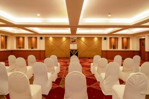 a conference room with white chairs and tables at The Residency Karur in Karūr