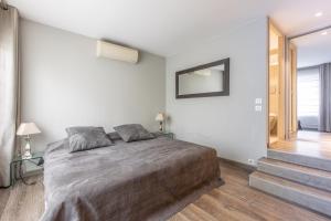 een slaapkamer met een bed en een spiegel aan de muur bij Heart of Cannes Luxury Stay - Steps from Beach & Palais in Cannes +72 foto's
