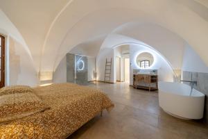 ein Schlafzimmer mit einem Bett und einer Badewanne in der Unterkunft Exceptionnel - Couvent entièrement rénové - classé Patrimoine - Piscine, au calme et à 100 m du coeur de l'Isle in LʼIsle-sur-la-Sorgue + 39 Fotos