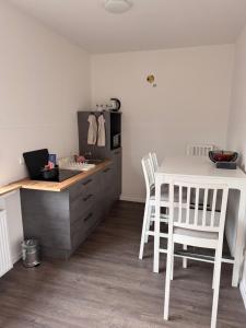 a kitchen with a white table and white chairs at Ovi Apartment in Vechta