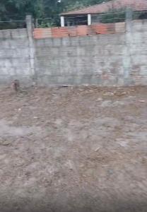 een hek in een tuin naast een veld bij Casa de sítio in Aquiraz