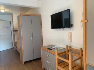 ein Zimmer mit einem Schreibtisch und einem Fernseher an der Wand in der Unterkunft Studio 4 Pers. à Brides-les-Bains avec WIFI et Parking - FR-1-512-131 in Brides-les-Bains