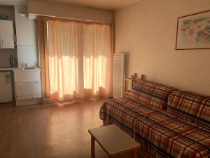 ein Wohnzimmer mit einer Couch und einem Fenster in der Unterkunft Studio 4 Pers. à Brides-les-Bains avec WIFI et Parking - FR-1-512-131 in Brides-les-Bains
