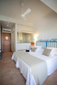 a bedroom with two beds with a laptop on it at Hostal la Savina in La Savina