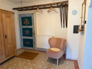 a living room with a chair and a door at Ferienwohnung Hörlkofen in Wörth +31 photos