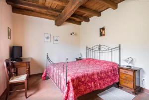 sypialnia z czerwonym łóżkiem i biurkiem w obiekcie Agriturismo Ca' Bertu' w mieście Zappolino