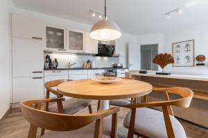 een keuken en eetkamer met een houten tafel en stoelen bij App 22, Strandresidenz Dünenperle in Kühlungsborn +10 foto's