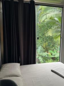 a bedroom with a large window with a bed and a window at Casa Container Moderna in Itajaí