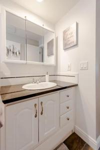 un bagno bianco con lavandino e specchio di Spacious 4 bdr w/ Game Room 5 min Drive to College a Boulder