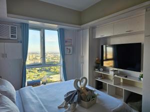 Schlafzimmer mit einem Bett, einem TV und einem Fenster in der Unterkunft 26th Sky View Home in Cebu City