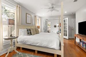 a bedroom with a white bed and a tv at Sunshine Daydreams - 4310 Seventh Street in Saint Simons Island