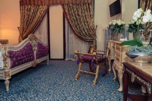 a living room with a purple couch and a chair at Hotel Tannenhof in Lauterbach