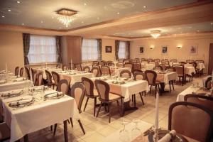 a banquet hall with white tables and chairs at Hotel Tannenhof in Lauterbach