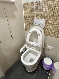 a bathroom with a toilet with the seat up at Puddings Tranquil Sunroom Retreat in Glen Waverley in Glen Waverley