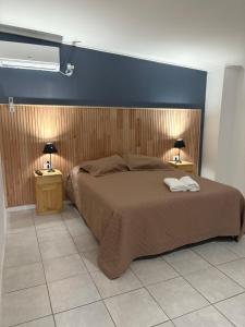 a bedroom with a bed with two lamps on two tables at Sabattini Apart in Villa María