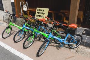 quattro biciclette parcheggiate sul marciapiede davanti a un negozio di Couch Potato Hostel - Vacation STAY 28455v a Matsumoto