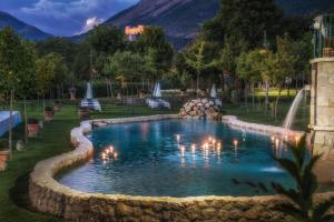 a swimming pool in a yard with a fountain at Hotel Ristorante le Gole di Ricci in Aielli