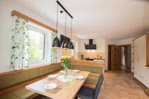 a kitchen and dining room with a wooden table and chairs at Ferienhaus zur Kundler Klamm by FeWo-Plan WILD012 in Dorf