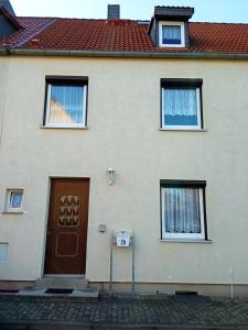 a house with a brown door and two windows at Ferienhaus am Geiseltalsee in Braunsbedra