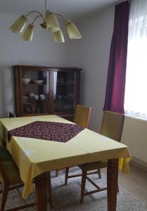 a dining room table with a yellow table cloth on it at Ferienhaus am Geiseltalsee in Braunsbedra +13 photos