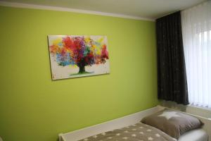 a bedroom with a painting of a tree on the wall at Wohnung Julius 1 in Sankt Andreasberg