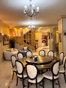 un salon avec une table, des chaises et un canapé dans l'établissement فيلا فرش فندقي في الشيخ زايد رقم الهاتف صفر صفر اتنين صفر واحد واحد صفر اتنين أربعه ثلاثه صفر 222, à Sheikh Zayed