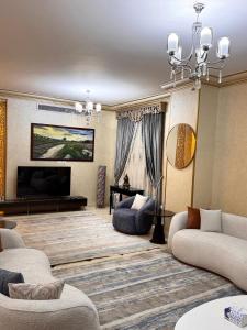 un salon avec un canapé et une télévision dans l'établissement فيلا فرش فندقي في الشيخ زايد رقم الهاتف صفر صفر اتنين صفر واحد واحد صفر اتنين أربعه ثلاثه صفر 222, à Sheikh Zayed