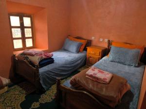 a bedroom with two twin beds and a window at Dar Megdaz in Megdaz