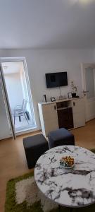 a living room with a table and chairs and a television at Apartman Rubin20 in Doboj