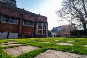 an old brick building with green grass in front of it at Westminster College in Cambridge