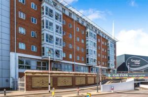 Un gran edificio de ladrillo con un cartel delante. en Modern studio apartment in Gunwharf, en Portsmouth