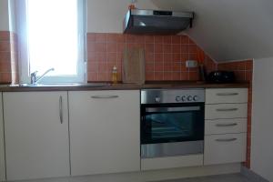a kitchen with white cabinets and a stove top oven at Ferienhaus direkt an See & Strand in Göhren-Lebbin