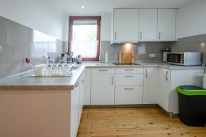 una cucina bianca con un lavello e un forno a microonde di Bungalow Merla - Kemnitz a Dahme