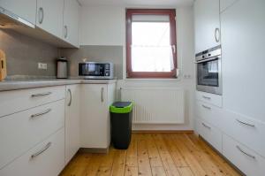 una cucina con armadi bianchi e un cestino verde di Bungalow Merla - Kemnitz a Dahme