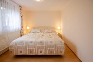 un grande letto in una stanza con due lampade di Bungalow Merla - Kemnitz a Dahme Altre 12 foto