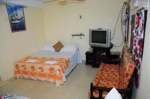 a bedroom with a bed and a tv and a chair at Manimalar guest in Colombo