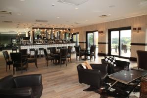 a restaurant with a bar with chairs and tables at National Golf Resort in Klaipėda