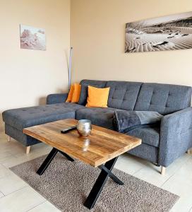 a living room with a blue couch and a wooden coffee table at Haus Tannenburg Whg 408 in Grömitz