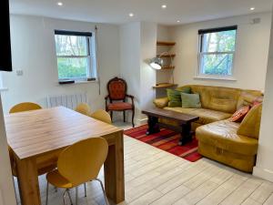 a living room with a couch and a table at Vernon Place town centre, Vernon Cottage 3-bed with parking, 1A Vernon Court 2-bed with parking, 1B studio no parking, off the High Street next to Sandford Park in Cheltenham