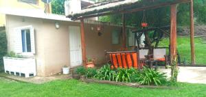 a house with a porch with two chairs and plants at Depto Valle del Sol,cerca GOLF CLUB VILLA ALLENDE in Mendiolaza