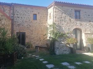 a stone house with a garden and a courtyard at Vecchio Casale Quercetino in Castel del Piano